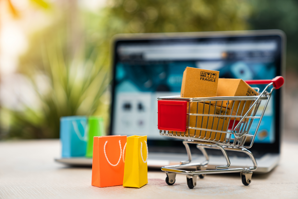 E-Commerce mit Einkaufswagen vor Laptop